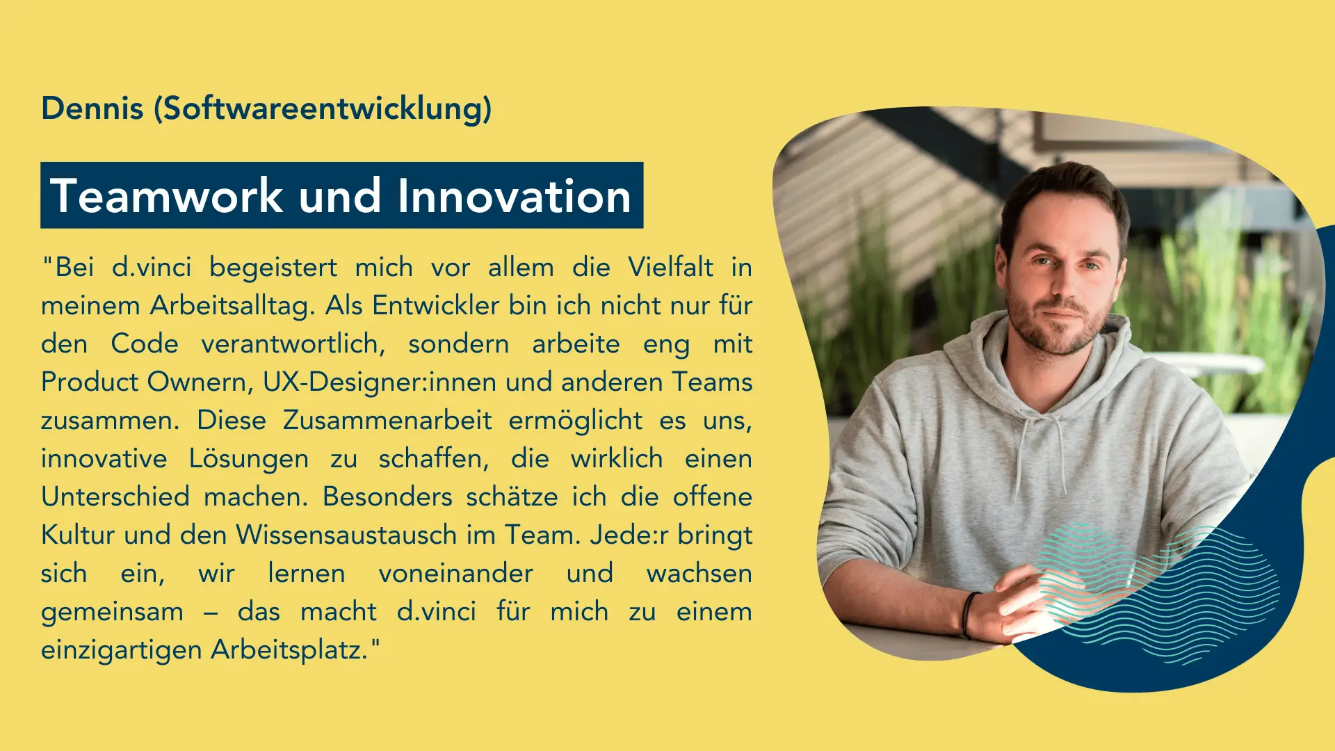 Person in einem hellgrauen Kaputzenpullover sitzt an einem Tisch in einem modernen, hellen Raum mit Pflanzen im Hintergrund.