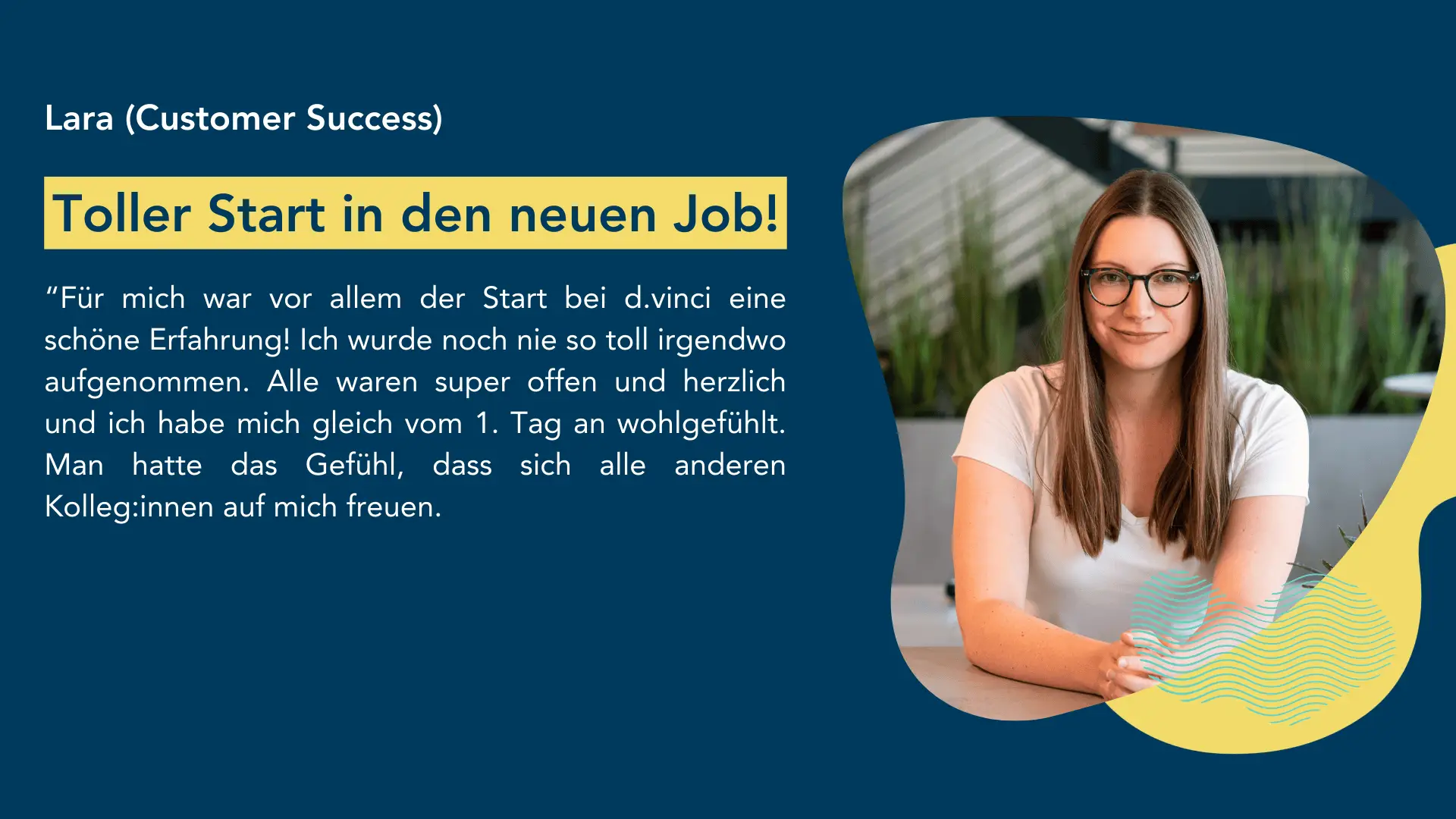 Person in einem weißen T-Shirt sitzt an einem Tisch in einem modernen, hellen Raum mit Pflanzen im Hintergrund.